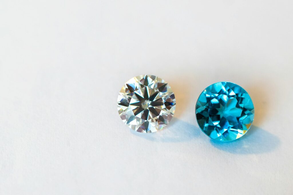 Vivid close-up of a round diamond paired with a stunning blue gemstone, showcasing brilliance.